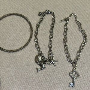 Three silver bracelets stack two with charms